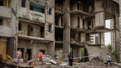 Local residents clear a territory at a residential building damaged by Monday's Russian missile attack in Kyiv, Ukraine, Tuesday, July 7, 2026. (Dan Bashakov/AP)