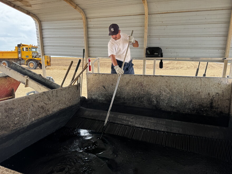AgTech worker demonstrates biosolids processing.