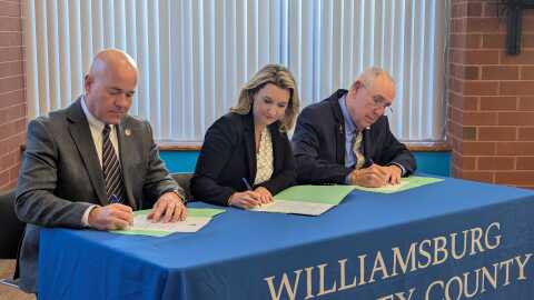 Williamsburg Mayor Doug Pons (left), WJCC School Board Chair Sarah Ortego (middle) and James City County Board of Supervisors Chair Jim Icenhour (right) sign a new funding agreement for the Williamsburg-James City County joint school division.