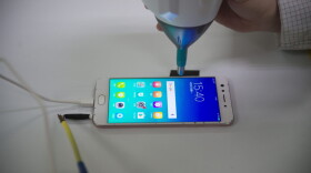 A smartphone receives electrical shocks at the testing facility of the Oppo factory in Dongguan, China. (Nicolas Asfouri/AFP via Getty Images)
