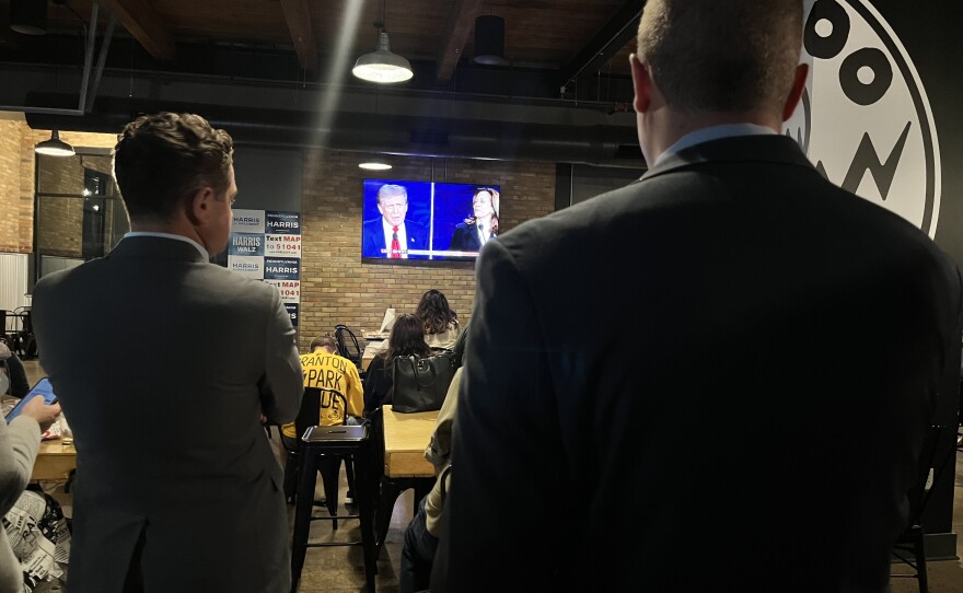 Two men listen to responses during Tuesday night's presidential debate during a Democratic watch party at Voodoo Brewing Co. in Scranton.