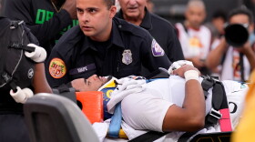 Oregon quarterback Dante Moore, bottom, is loaded into an ambulance following a hard tackle by Southern California linebacker Desman Stephens II during the first half of an NCAA college football game, Saturday, Sept. 26, 2026, in Los Angeles.