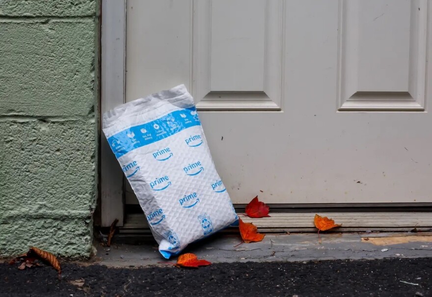 A plastic Amazon package is sitting outside of the door.
