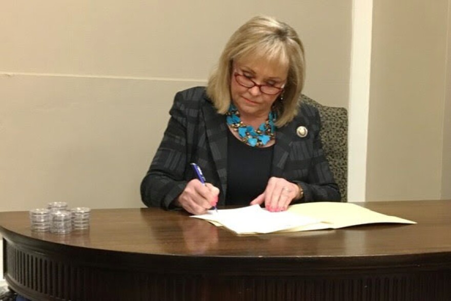 Governor Mary Fallin signs paperwork that commuted the sentences of 21 nonviolent offenders who were incarcerated for 10 years or more for offenses that now carry either no prison term or a significantly shorter prison term.