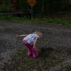 Paige Casto stops to admire a butterfly. She was a toddler when her family first began being photographed by Maddie McGarvey.