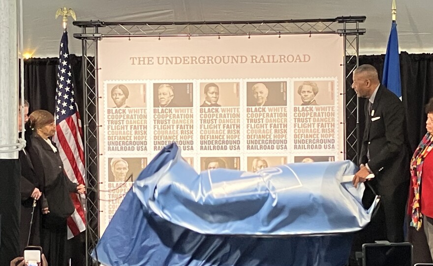 Millicent Sparks as Harriet Tubman and The Honorable Ronald Stroman, Board of Governors, United States Postal Service, unveil the new underground railroad stamps. Photo by John Lee/WYPR. 