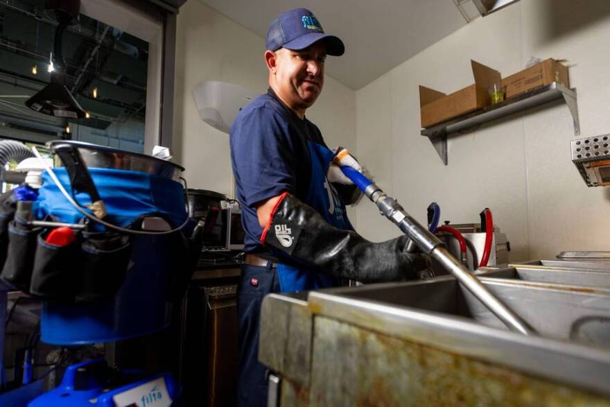 Filta service technician Richard Erin uses the vacuum-based filtration system to clean out a fryer at Cerveceria La Tropical in the Wynwood section of Miami, on Wednesday, May 24, 2023.