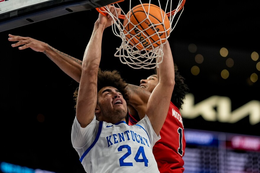Kentucky center Malachi Moreno (24) dunks against St. John's forward Dillon Mitchell (1) during the first half of an NCAA basketball game, Saturday, Dec. 20, 2025, in Atlanta. (AP Photo/Mike Stewart)