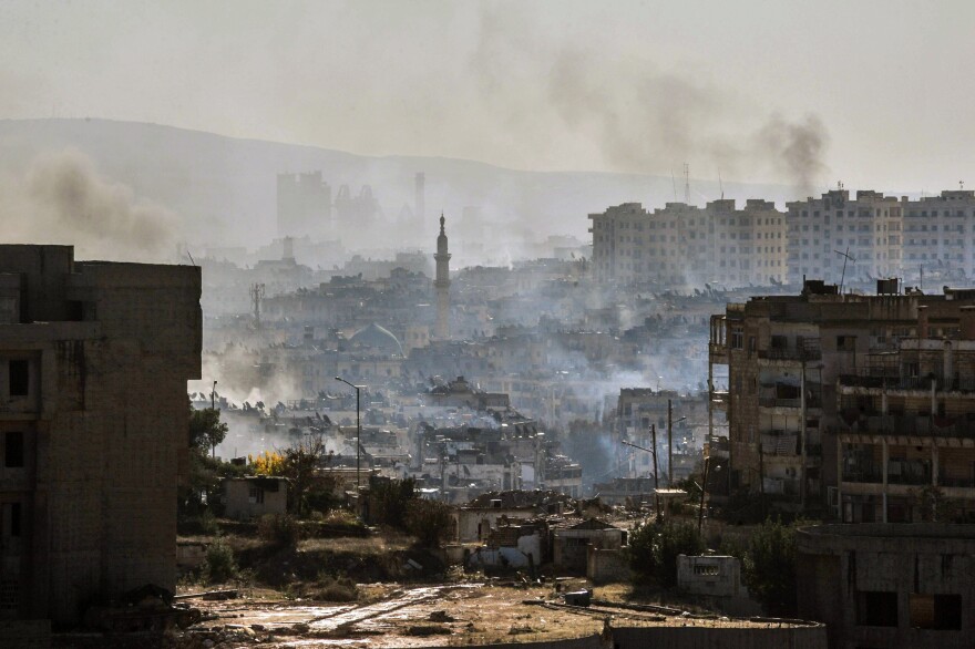 In this photo released by the Syrian official news agency SANA, smoke rises in an east Aleppo neighborhood in Syria on Thursday.
