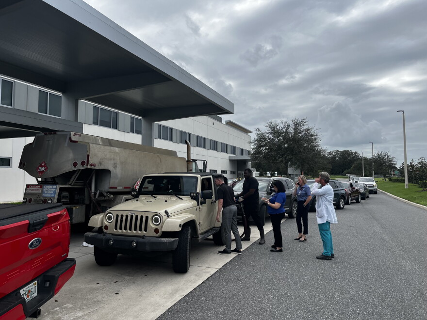 Cars in a line with people assisting