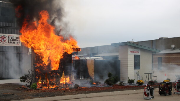 The home with normal building materials is completely engulfed in flames while the fire-treated home remains intact during a demonstration at the West Metro Fire Rescue Training Center on Thursday, Sept. 17, 2026, in Lakewood, Colo.