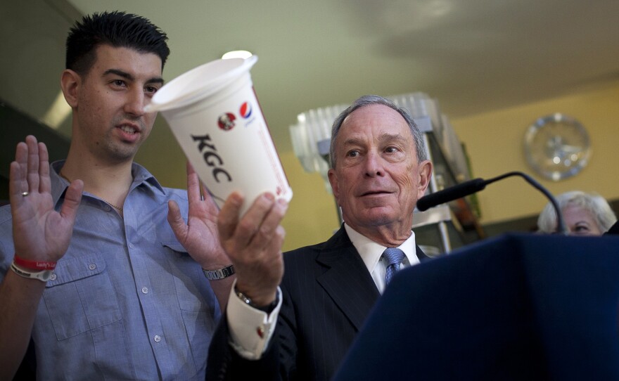 Bloomberg holds a large cup as he speaks to the media about the effects of sugar on health at Lucky's restaurant, which voluntarily adopted a ban on large sugary drinks, March 12 in New York City. A state judge blocked Bloomberg's ban.