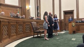 Washington state Supreme Court Justice Theo Angelis dons his robe alongside wife Kim and children Katherine and John as he is sworn in as a justice at the Temple of Justice on Monday, May 18, 2026, in Olympia.