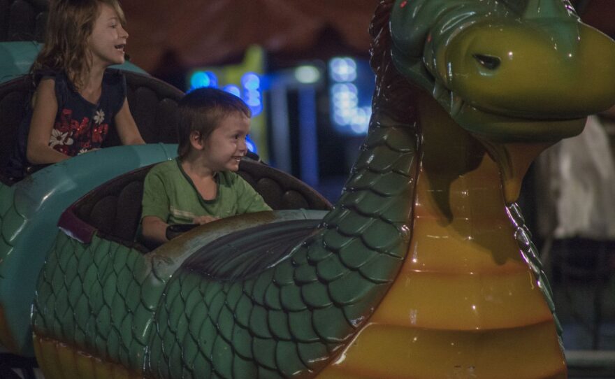 Two children enjoy a dragon ride at the Alachua County Fair. Children 5 years old and under are admitted free at the fair. Nikhil Johns/WUFT News