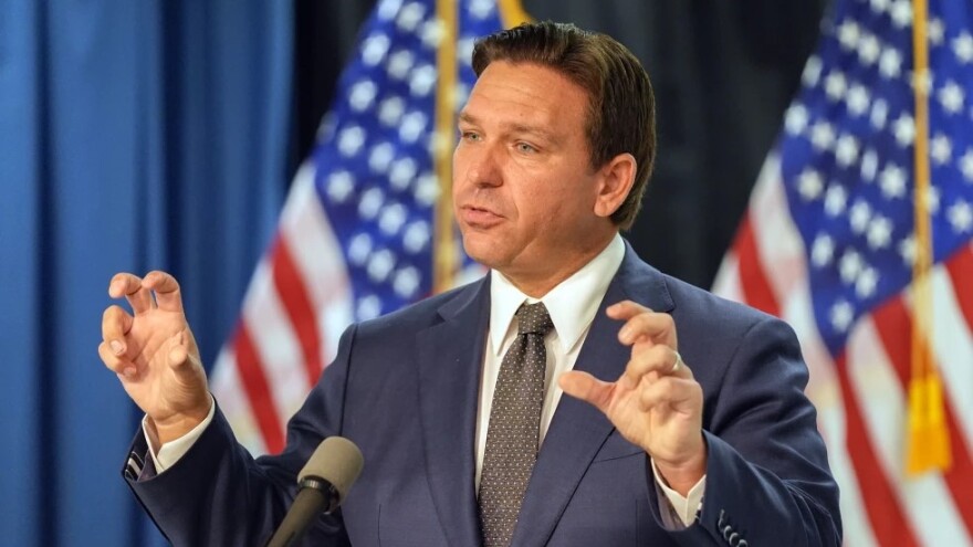 Man is suit stands at podium and speaks 