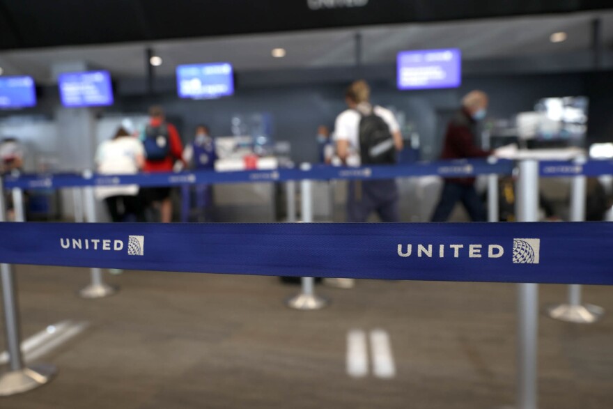 SAN FRANCISCO, CALIFORNIA - OCTOBER 19: The United Airlines is displayed on a retractable barricade at San Francisco International Airport on October 19, 2021 in San Francisco, California. United Airlines will report third-quarter earnings today after the closing bell on the Stock Exchange. (Photo by Justin Sullivan/Getty Images)