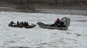 Conservation officers on an airboat (right) arrive to rescue hunters on the frozen White River Saturday, Jan. 24, 2026