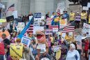 Protestors wave signs as thunder begins to rumble near the end of the No Kings demonstration at the Missouri State Capitol in Jefferson City, Missouri, Oct. 18, 2025.