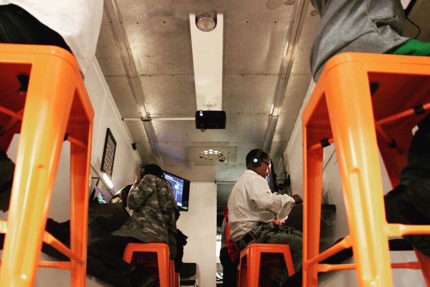 Teens seated inside the Mobile CRTV (Creative) lab.