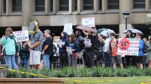 Protesters held signs silently in front of Cleveland State's Student Center. Many expressed outrage and sadness of at the abrupt closure and sale of the university's WCSB 89.3 to Ideastream Public Media.