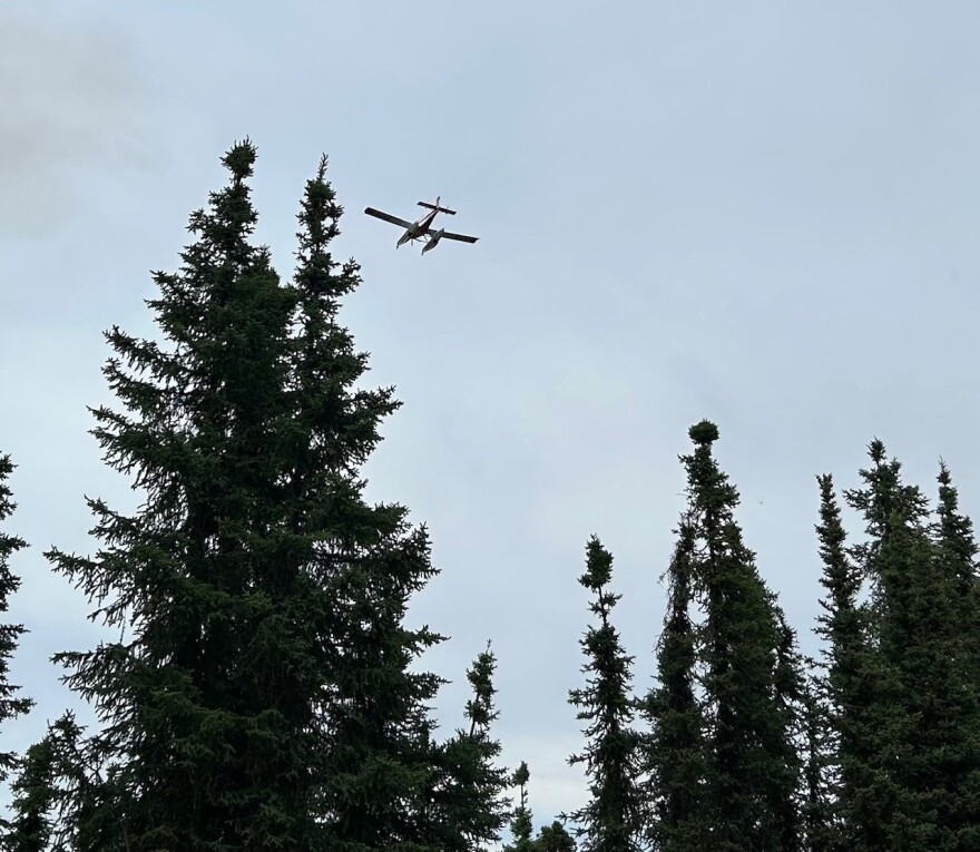 Firefighting plane, working the Gilmore Trail Fire, flies over Mt Lulu north of Fairbanks on June 19, 2025.