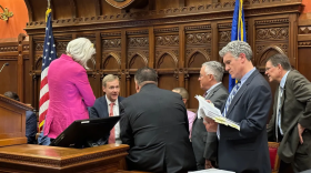 House Speaker Matt Ritter, seated, assures Republicans that a pharmacy licensing bill inserted into the budget would be removed. The huddle took place minutes before the budget debate began.