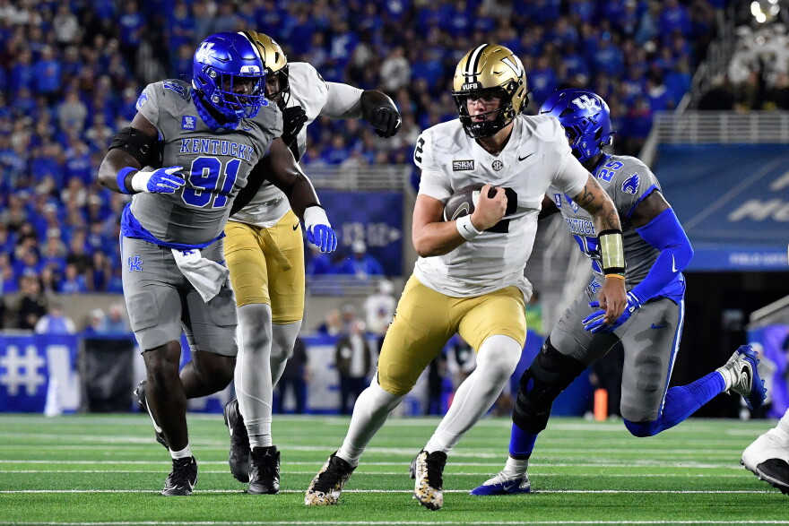 Vanderbilt quarterback Jared Curtis (2) is chased by Kentucky defensive lineman Jaden Williams (91) as he runs through an opening in the defensive line during the first half of an NCAA college football game in Lexington, Ky., Saturday, Oct. 24, 2026. (AP Photo/Timothy D. Easley)