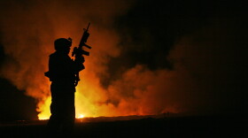 Sgt. Robert B. Brown with Regimental Combat Team 6 watches over the civilian firefighters at a burn pit in Fallujah, Iraq, on May 25, 2007. The appearance of U.S. Department of Defense (DoD) visual information does not imply or constitute DoD endorsement.