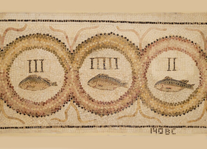 A tan and brown mosaic of three fish, each contained in its own circle along with a roman numeral (III with the first, IIIII with the second, and II with the third), "140 BC" is written on the bottom right