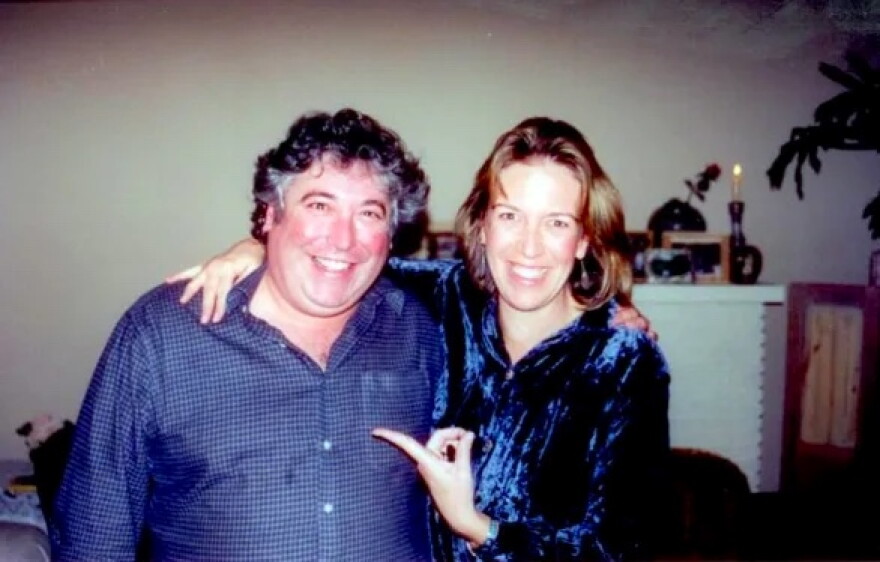 Two smiling people face the camera.