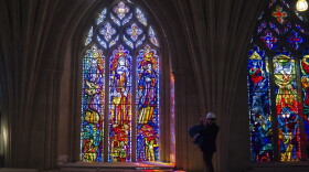 A reporter takes a photograph of a stained glass window at  the Washington National Cathedral. (Cliff Owen/AP)