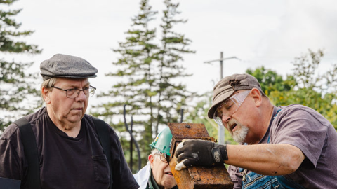 Designated safe-crackers peer into the metal box they found inside the century-old safe in Harrisville, Michigan on Sept. 20, 2026.
