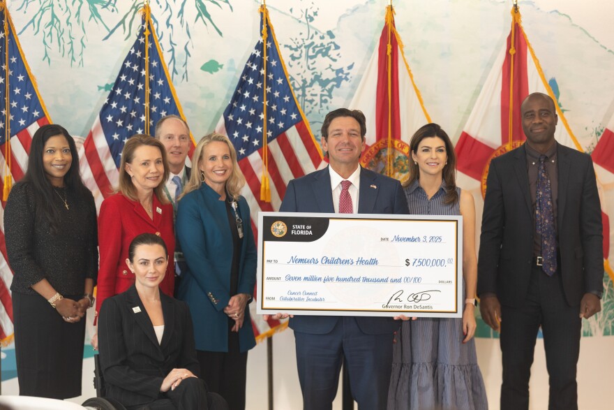 Officials from Nicklaus Children’s Hospital in Miami receive a $7.5 million check from Florida Gov. Ron DeSantis after earning a grant from the Cancer Connect Collaborative Research Incubator program within the Florida Department of Health on Monday, Nov. 3, 2025 in Jacksonville. The incubator will provide $7.5 million annually for each of the next five years.