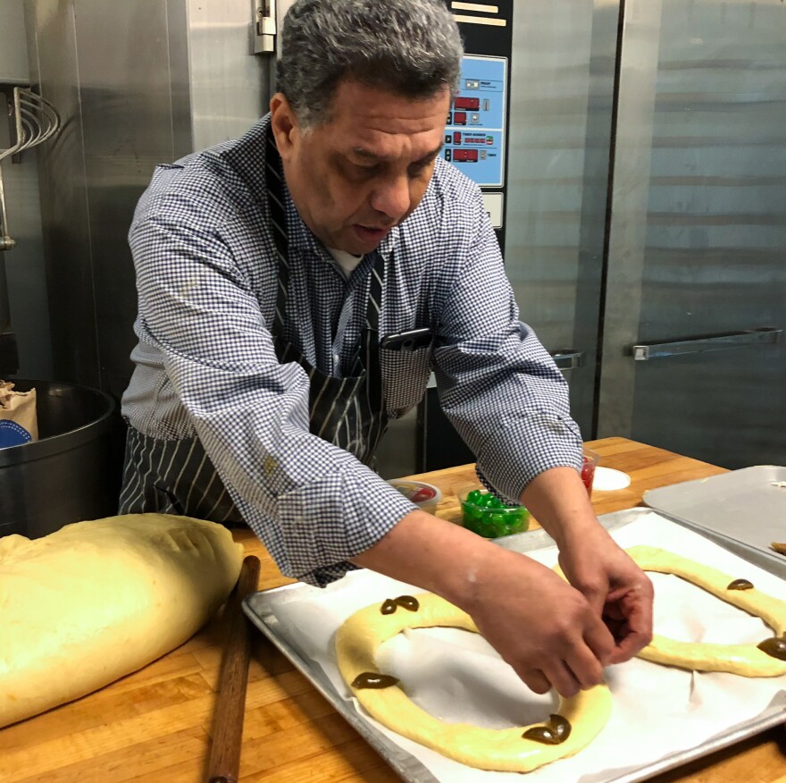 Carlos Benitez, owner of La Mexicana Bakery and Taqueria outside Washington, D.C., puts decorations on <em>rosca de reyes</em> before it goes into the oven. This year Benitez expects to sell almost 300 of the cakes.