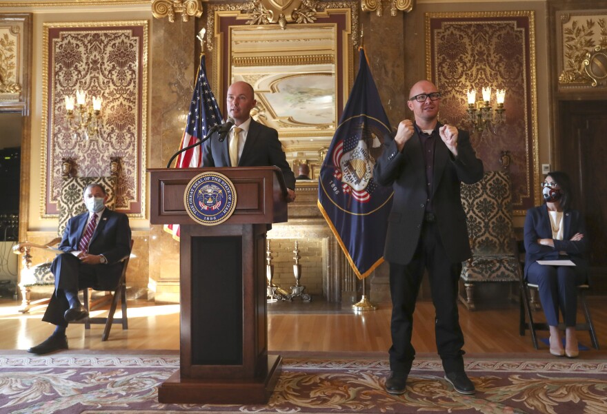 Gov. Gary Herbert, left, and Lt. Gov.-elect Deidre Henderson, right, listens as Gov.-elect Spencer Cox announces details related to their upcoming transition of leadership in the Gold Room at the Capitol in Salt Lake City on Thursday, Nov. 5, 2020.