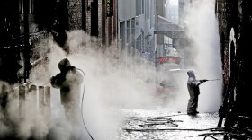 Workers steam-clean decades of gum off Seattle's famous "gum wall" on Tuesday. Tourists and locals have been sticking chewing gum to the wall near Pike Place Market for 20 years, leaving an estimated 1 million pieces in a kaleidoscope of colors, some stretched and pinched into messages, hearts and other designs.