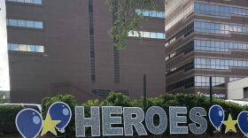 Outside Oshner Baptist hospital in New Orleans, a volunteer puts up decorations celebrating healthcare workers helping combat the coronavirus.