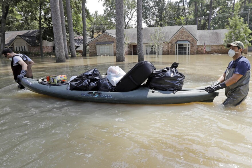 Gaston Kirby, left, is helped by friend Juan Minutella after gathering the last of his belongings from his flooded home in the aftermath of Hurricane Harvey Monday, Sept. 4, 2017 in Houston. (David J. Phillip/AP)