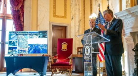 Gov. Dan McKee speaks at a statehouse news conference on Oct. 15, while Chief of Staff Joseph Almond looks on.