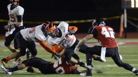 Princeton's Alex Momenee, center, picks up yardage during the second half of an NCAA college football game against Mansfield in Mansfield, Pa. on Sept. 14, 2013. Sports teams at six state-owned Pennsylvania universities will still compete against each other despite merging into two umbrella institutions, the State System of Higher Education announced Wednesday, April 20, 2022. The decision by the NCAA Division II Membership Committee pertains to sports in Division II at Bloomsburg, Lock Haven, Mansfield, California, Clarion and Edinboro universities.