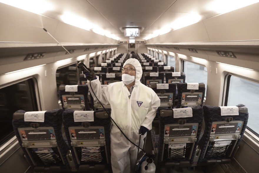 An employee sprays disinfectant on a train as a precaution against a new coronavirus at Suseo Station in Seoul, South Korea, on Friday.