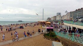 Despite cloudy weather, beaches are packed in Brighton, England. With airfares rising and the British pound down after the Brexit vote, some Britons are vacationing closer to home.