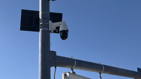 Surveillance cameras mounted to  a lightpole. 