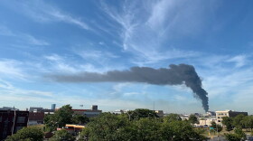 Smoke from a fire at a junkyard on the city's near west side is visible from WFYI around 10:30 a.m. Tuesday.