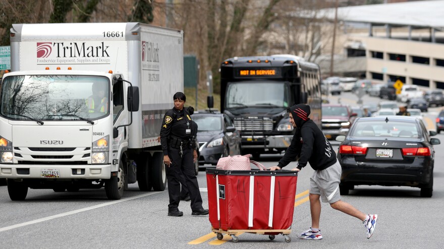 A Towson University student removes belongings out of the dorms as the school shut down days before the start of the scheduled spring break on March 11 in Towson, Maryland.