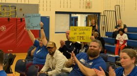 Cleveland schools teachers hold signs up during a CMSD Board of Education meeting on Tuesday, March 18 protesting proposed cuts to the district's extended-calendar schools.