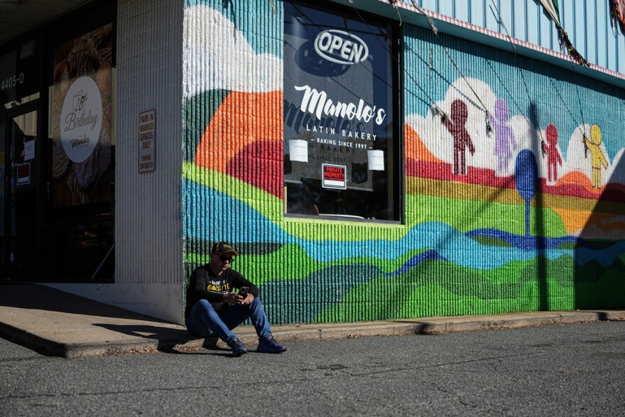 Manuel ‘Manolo’ Betancur sits outside of his bakery which is closed amidst federal law enforcement presence, Monday, Nov. 17, 2025, in Charlotte, N.C.