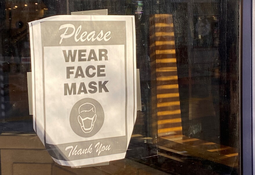 A sign outside an business in Uptown Normal urges people to wear a mask to help prevent the spread of COVID-19.