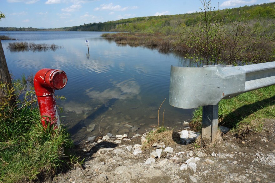 A section where boaters can launch onto Berlin Pond from Mirror Lake Road, in Berlin, with a red hydrant and a guardrail.