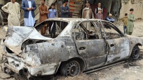 Residents view a vehicle damaged by a rocket attack Monday in Kabul, Afghanistan. Rockets struck a neighborhood near the Kabul airport amid the ongoing U.S. withdrawal from the country.